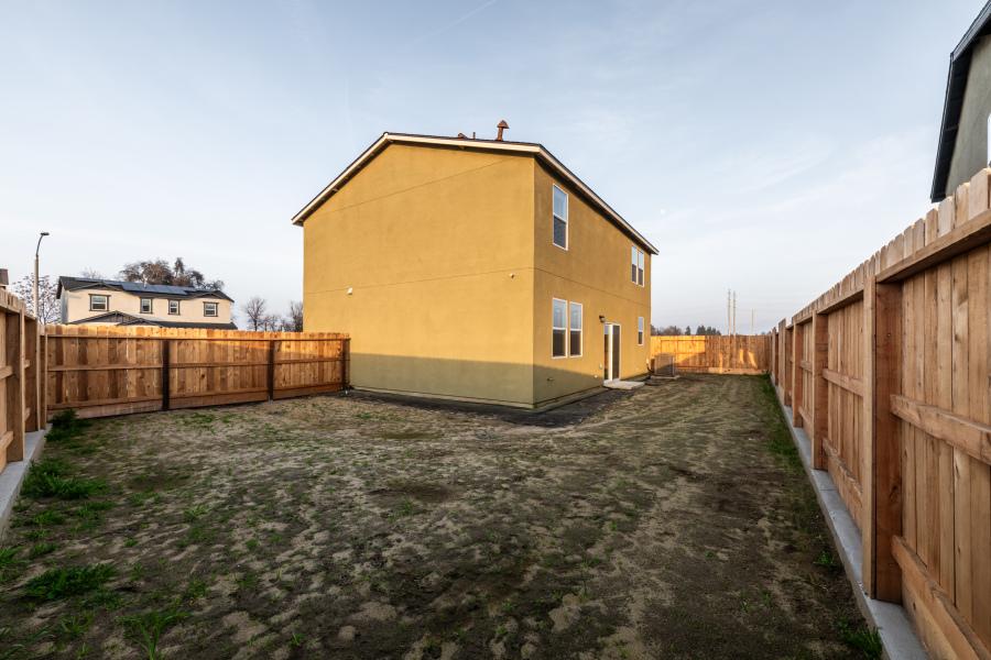 A yellow building with a fence around it.