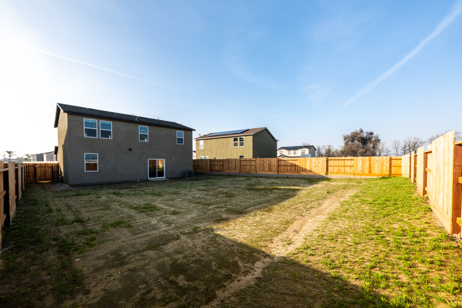 A dirt road leading to a house.