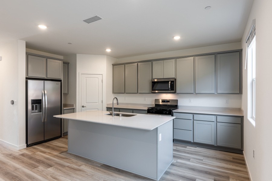 A kitchen with white cabinets.