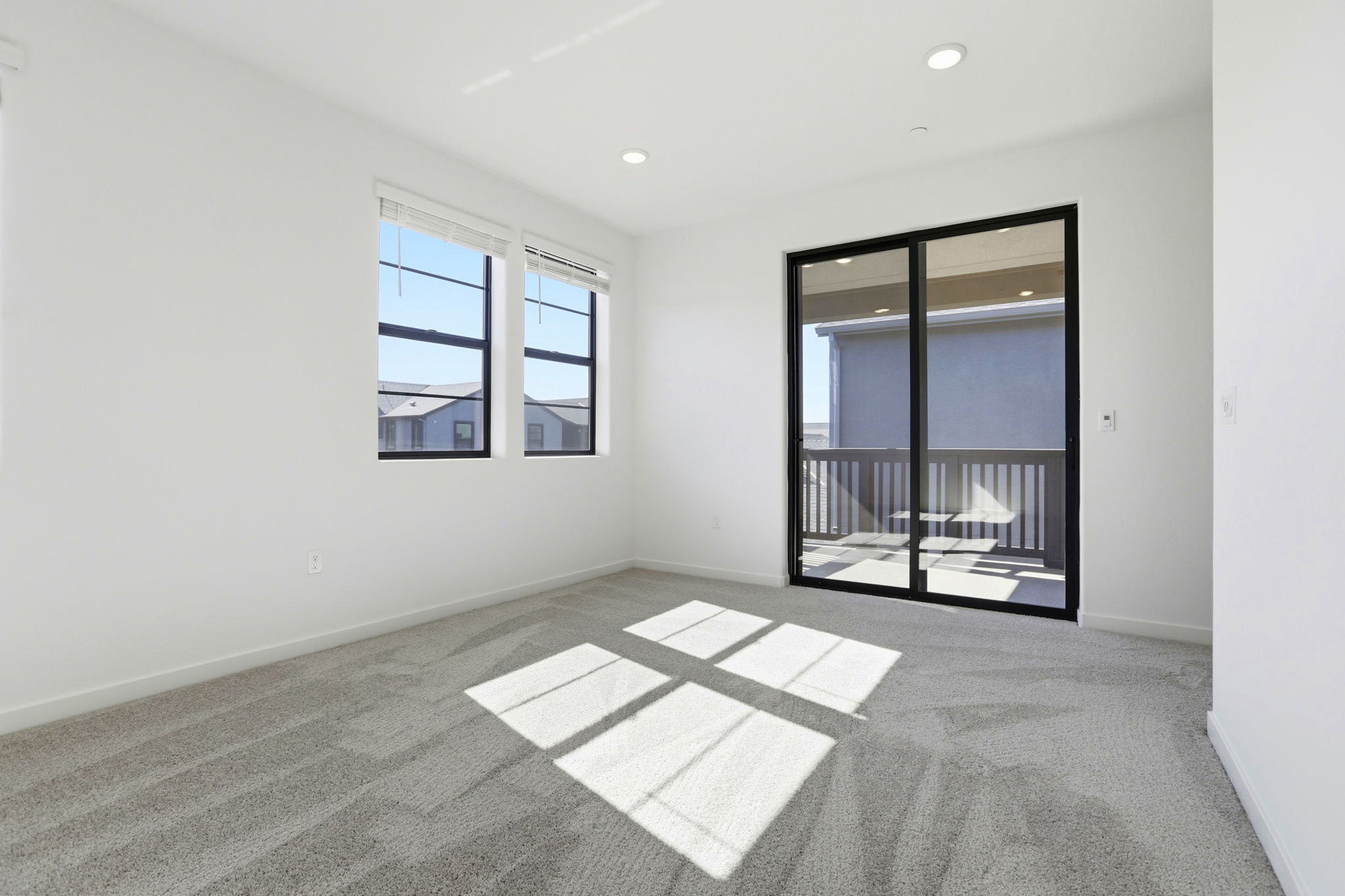 A room with a glass door and a window with a view of the water.