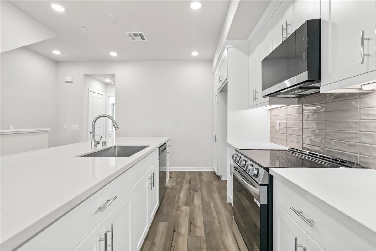 A kitchen with white cabinets.