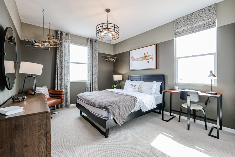 A bedroom with a bed desk and a mirror.