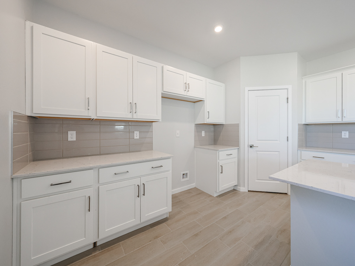 A kitchen with white cabinets.