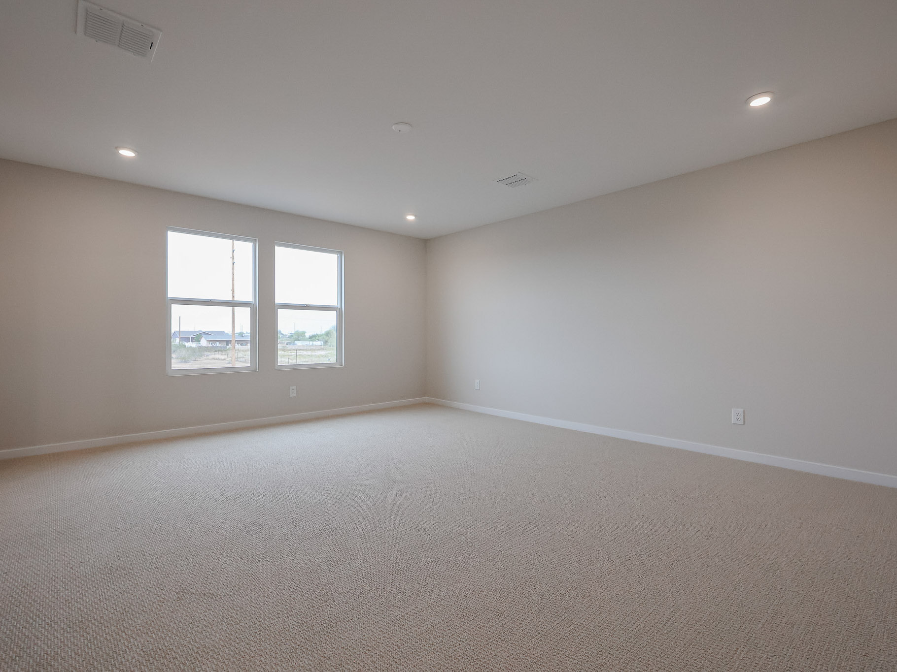 A room with a carpet and windows.