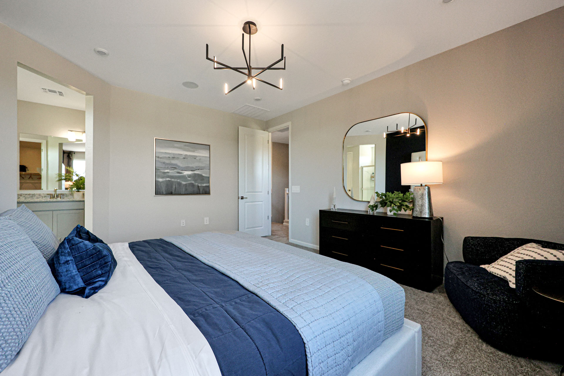 A bedroom with a bed and a mirror.