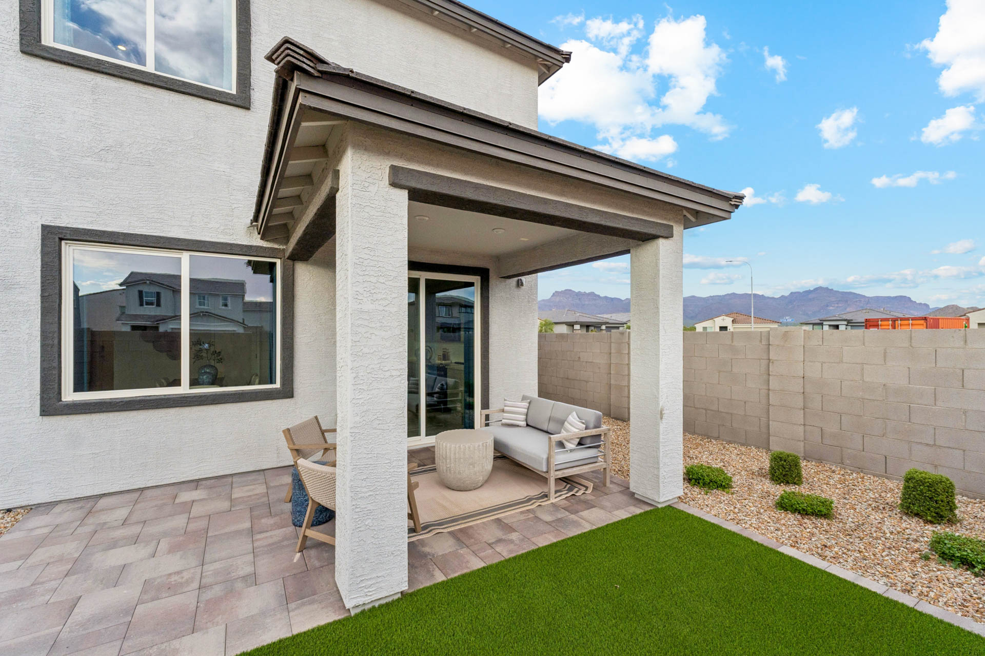 A house with a patio and a patio with a table and chairs.