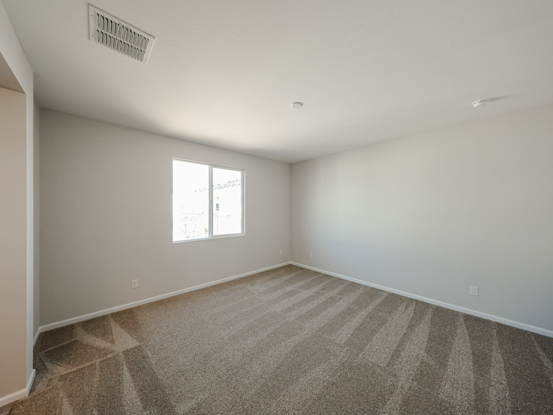 A room with a carpet and a window.