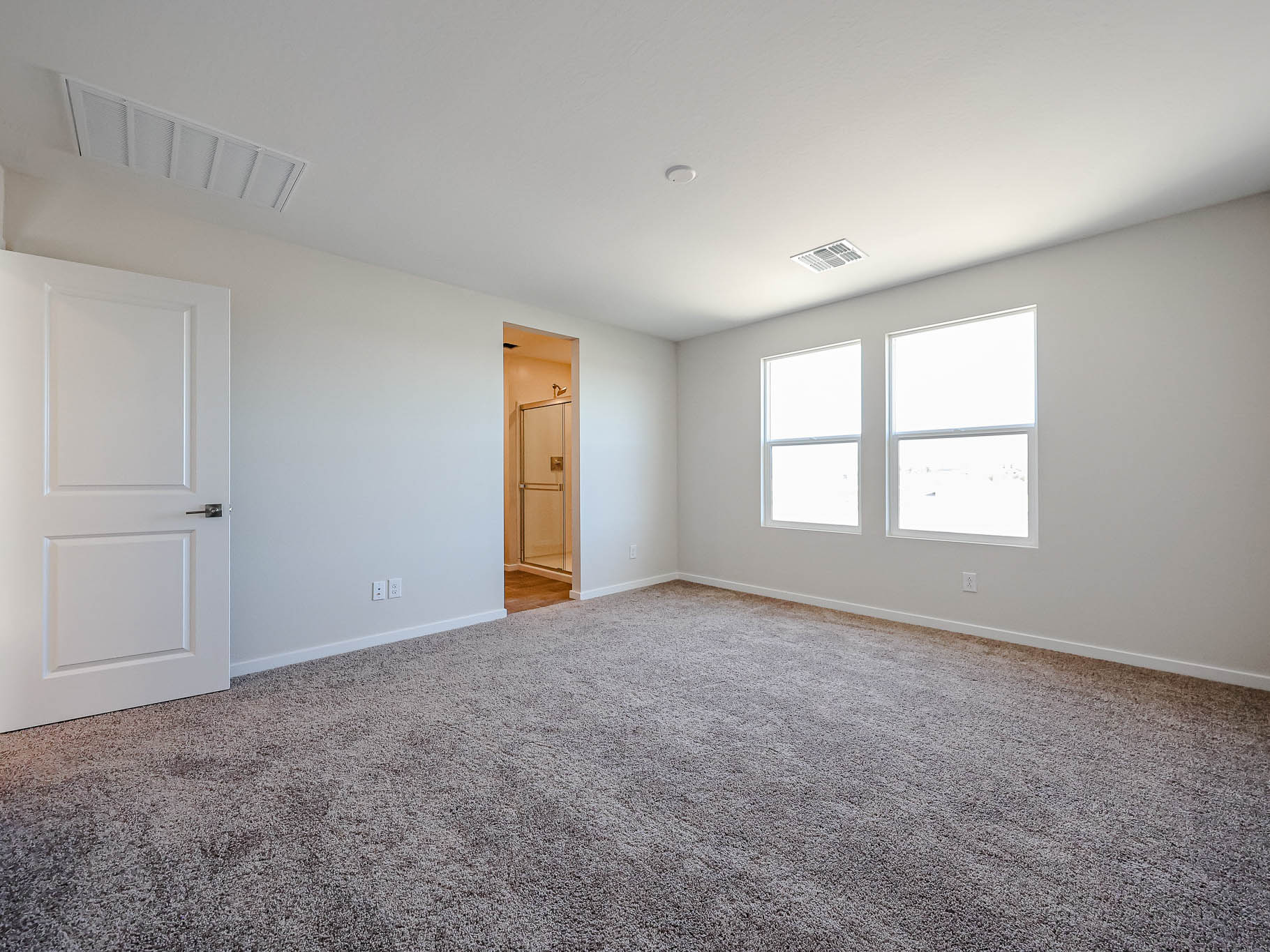 A room with a carpet and a door.