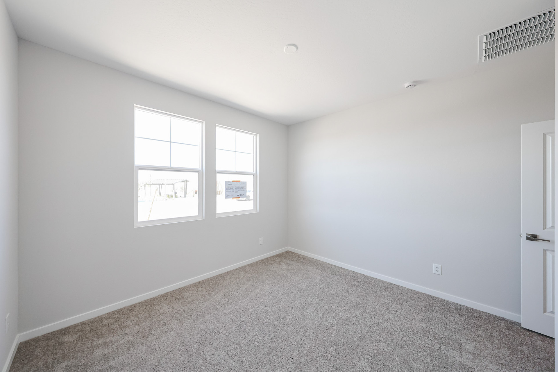 A room with a carpet and windows.