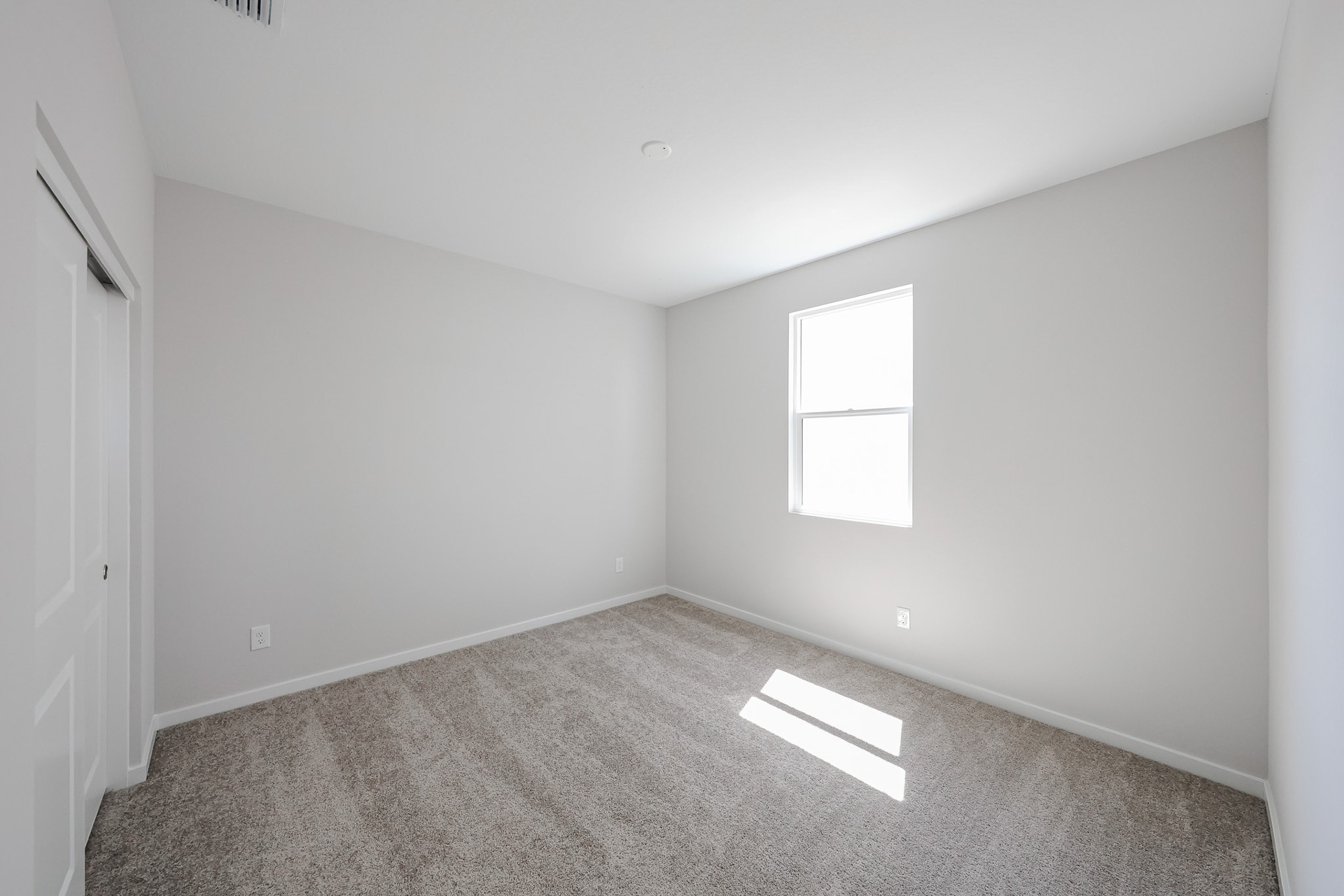 A room with a carpet and a door.