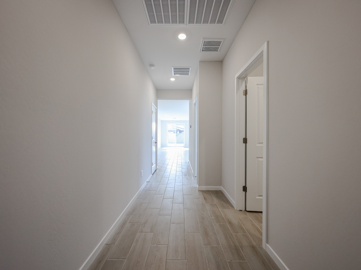 A long hallway with white doors.