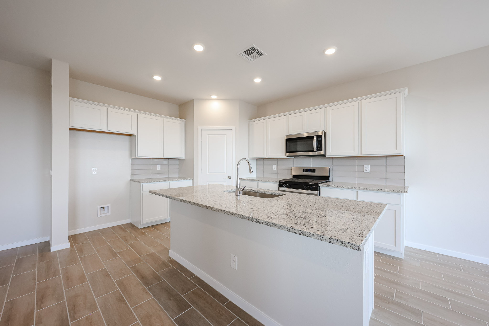 A kitchen with white cabinets.