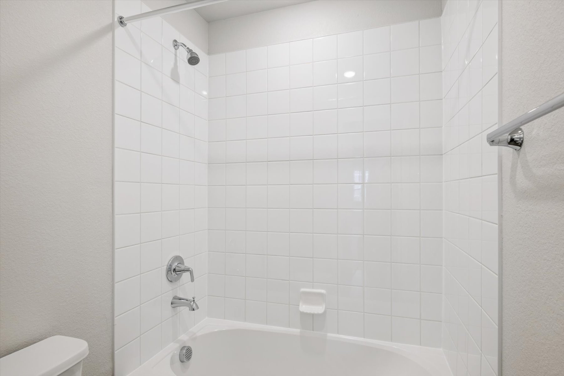 A white bathroom with a bathtub.