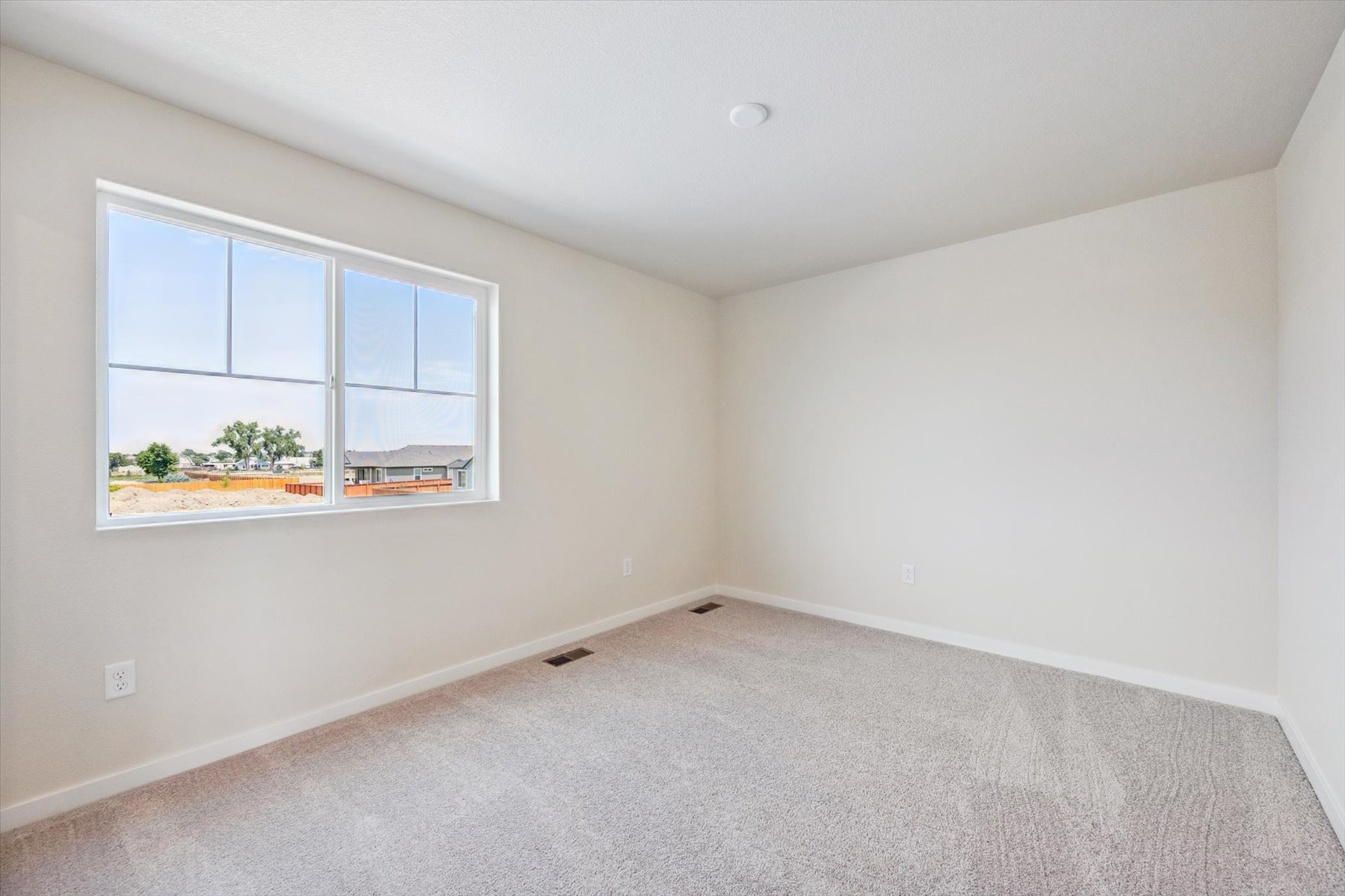 A room with a carpet and a window.
