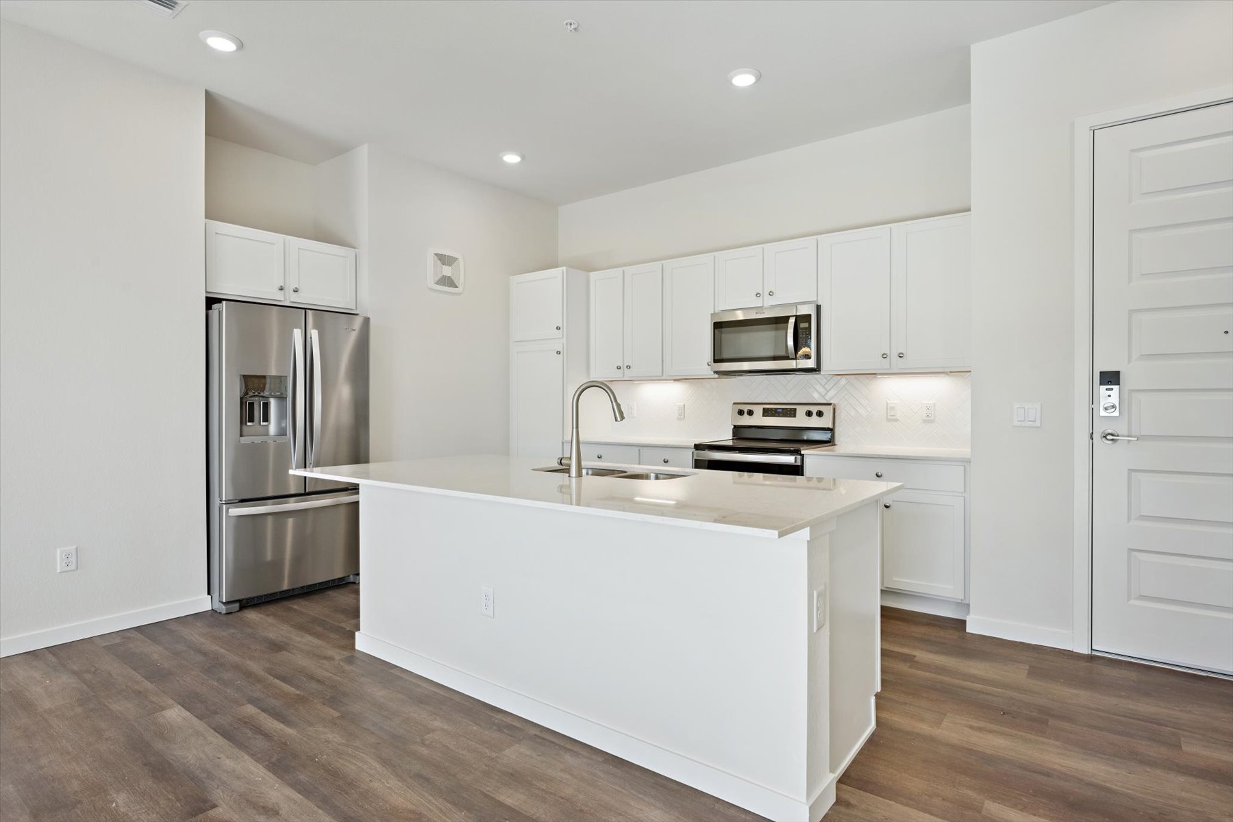 A kitchen with white cabinets.