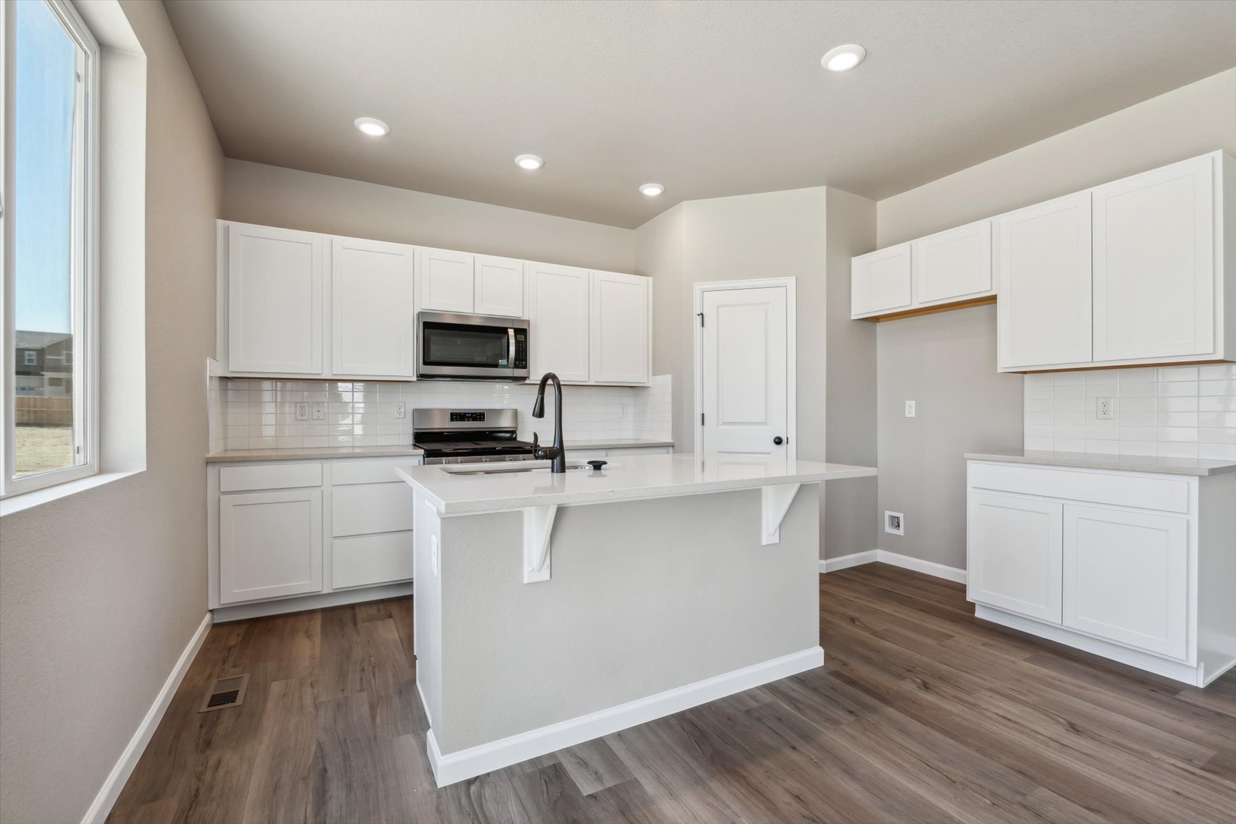 A kitchen with white cabinets.