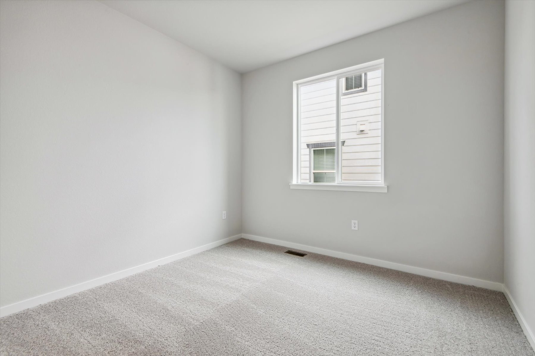 A room with a window and a carpet.
