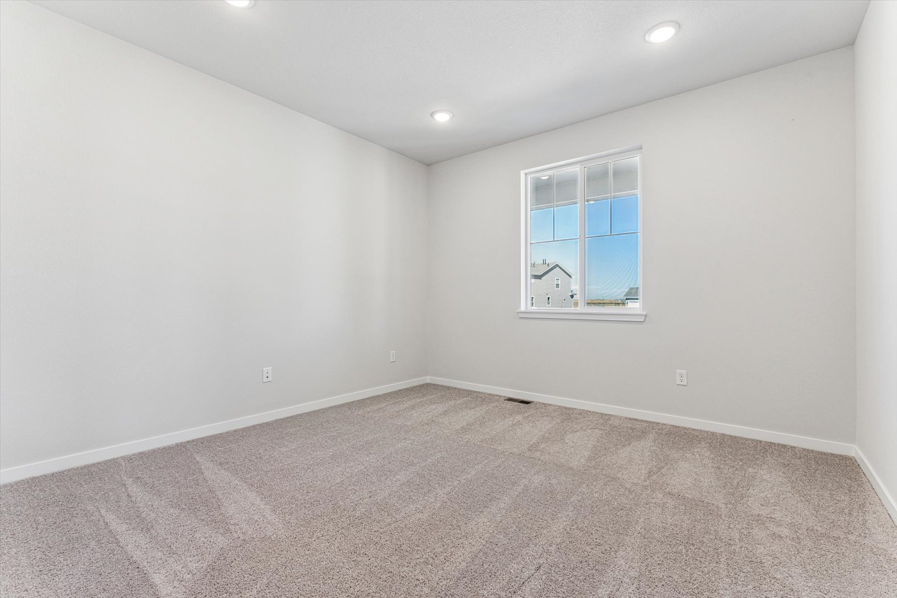A room with a window and a carpet.