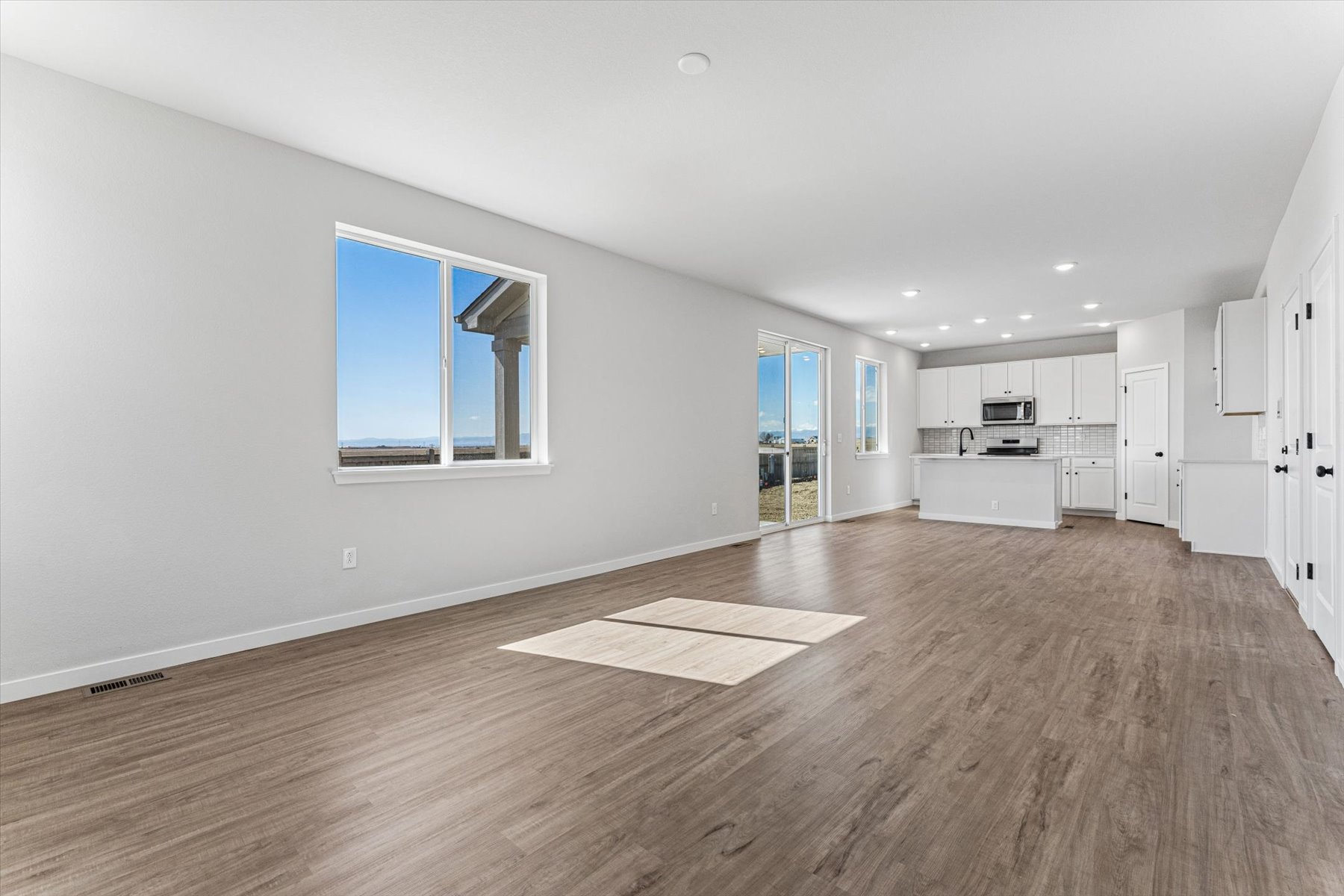 A large empty room with a wood floor and a wood floor.