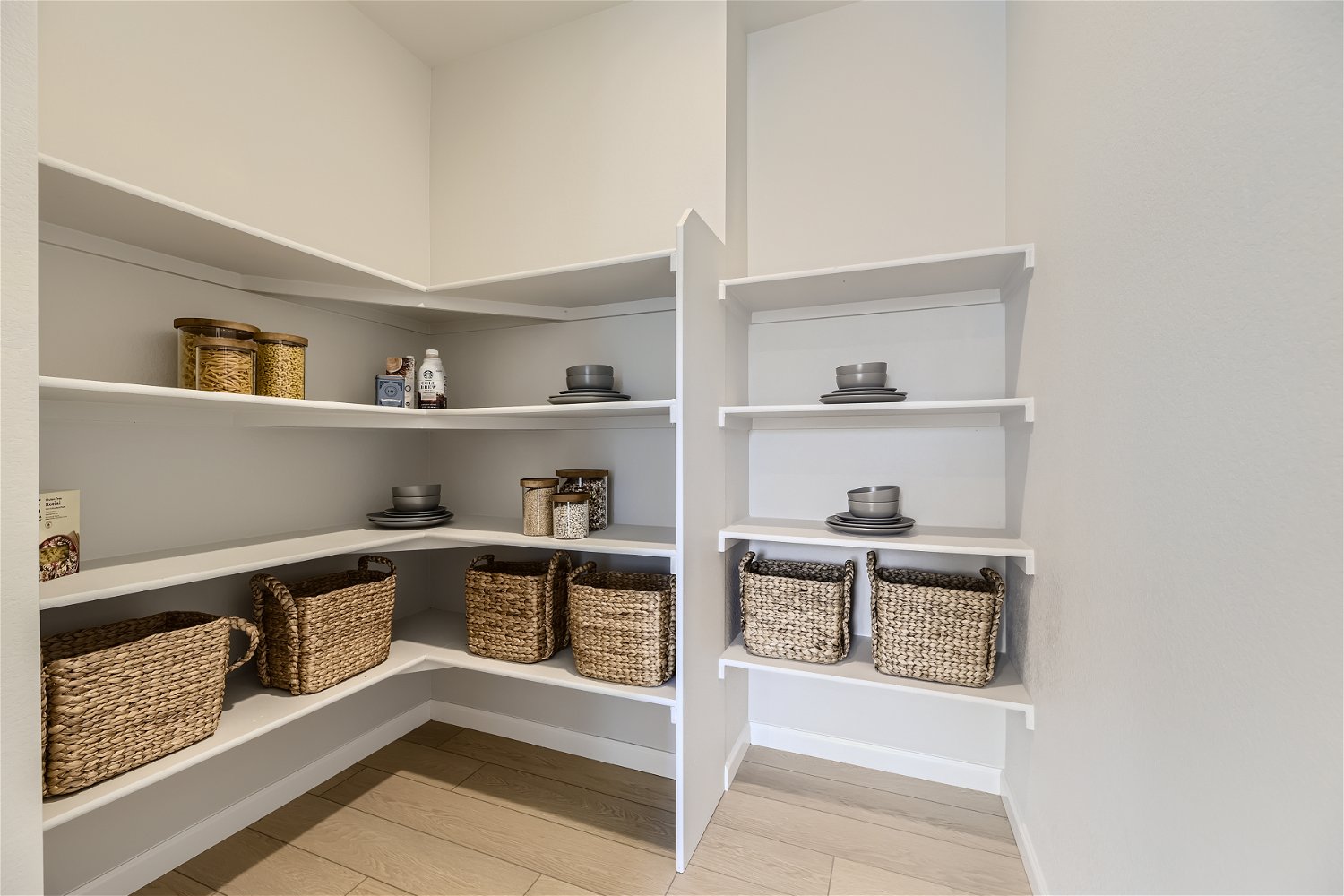 A white shelving unit with baskets and baskets.
