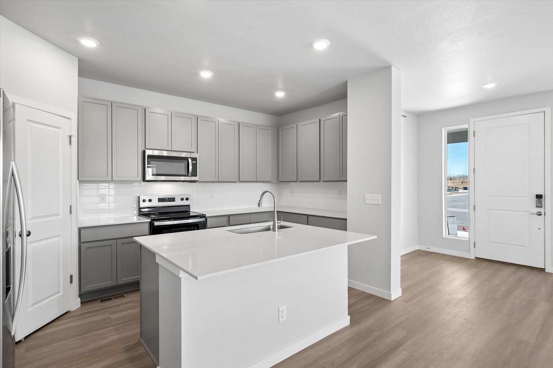 A kitchen with white cabinets.