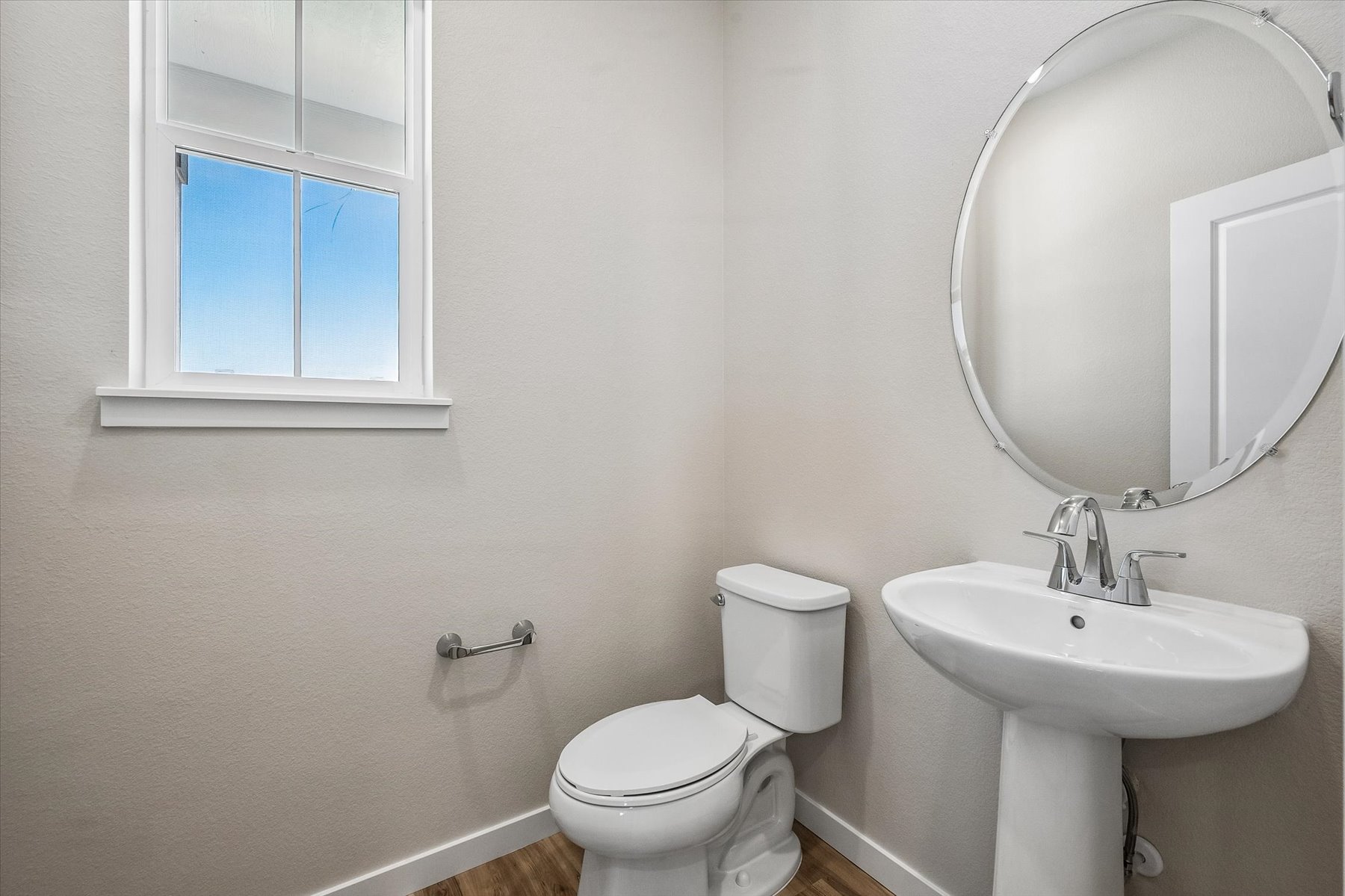 A bathroom with a round mirror.