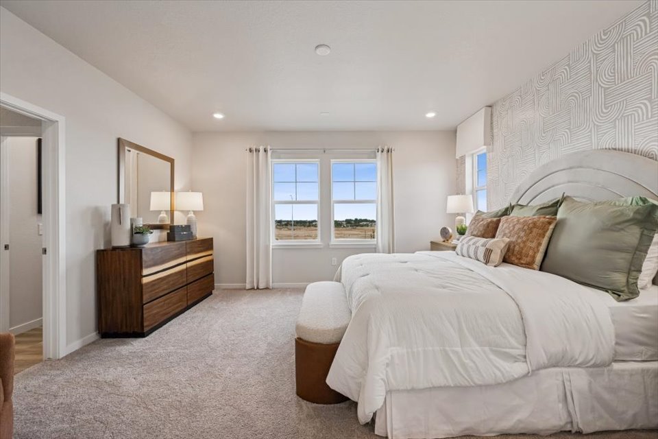 A bedroom with a bed and a desk.