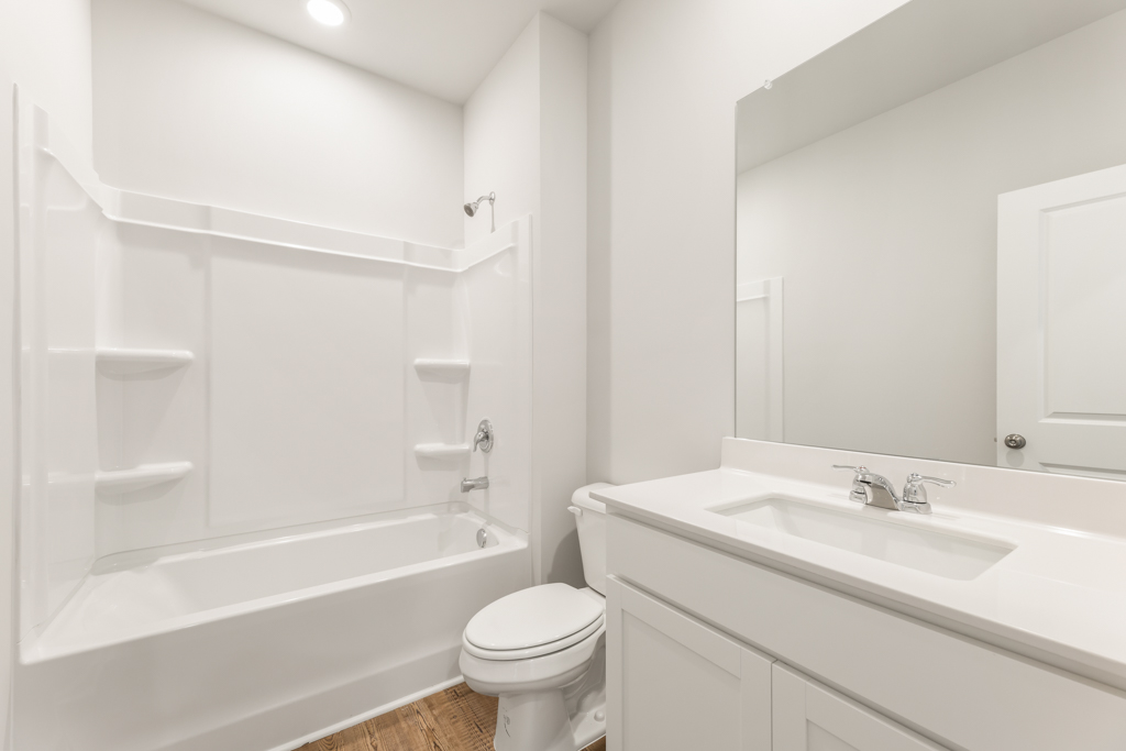 A bathroom with a tub sink and toilet.