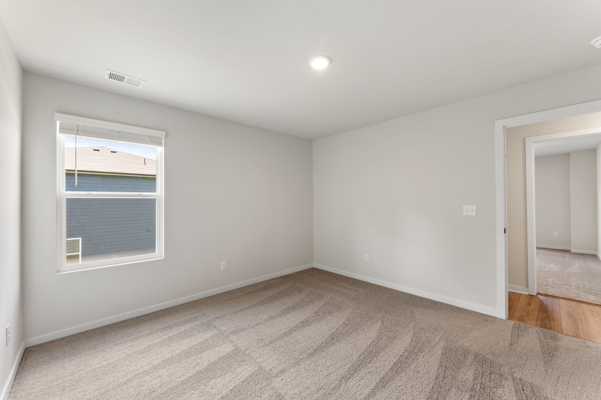 A room with a carpet and a window.