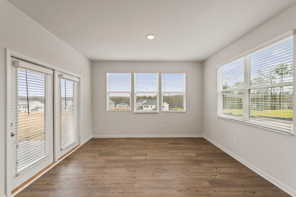 A room with windows and wood floors.