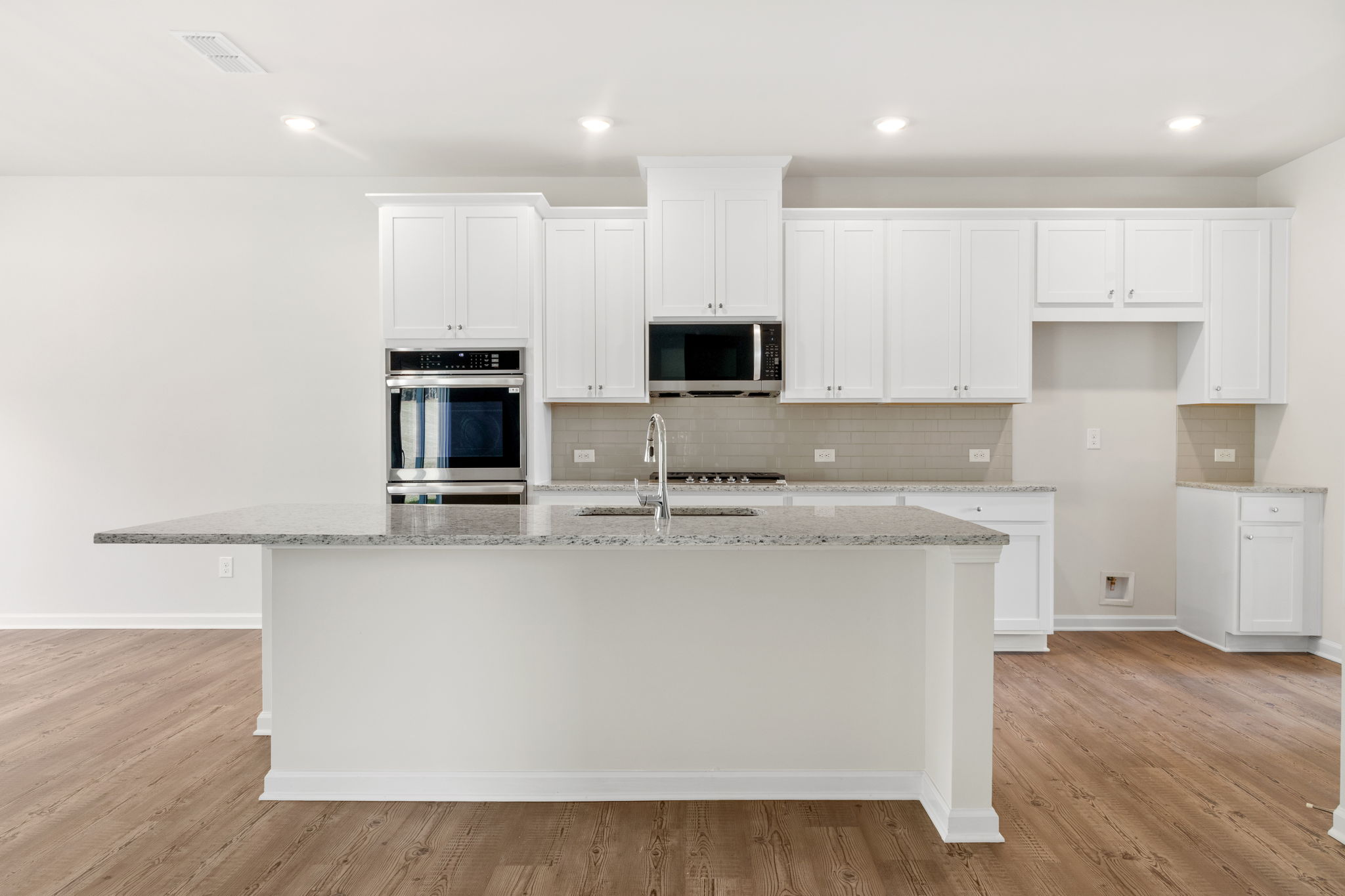 A kitchen with white cabinets.