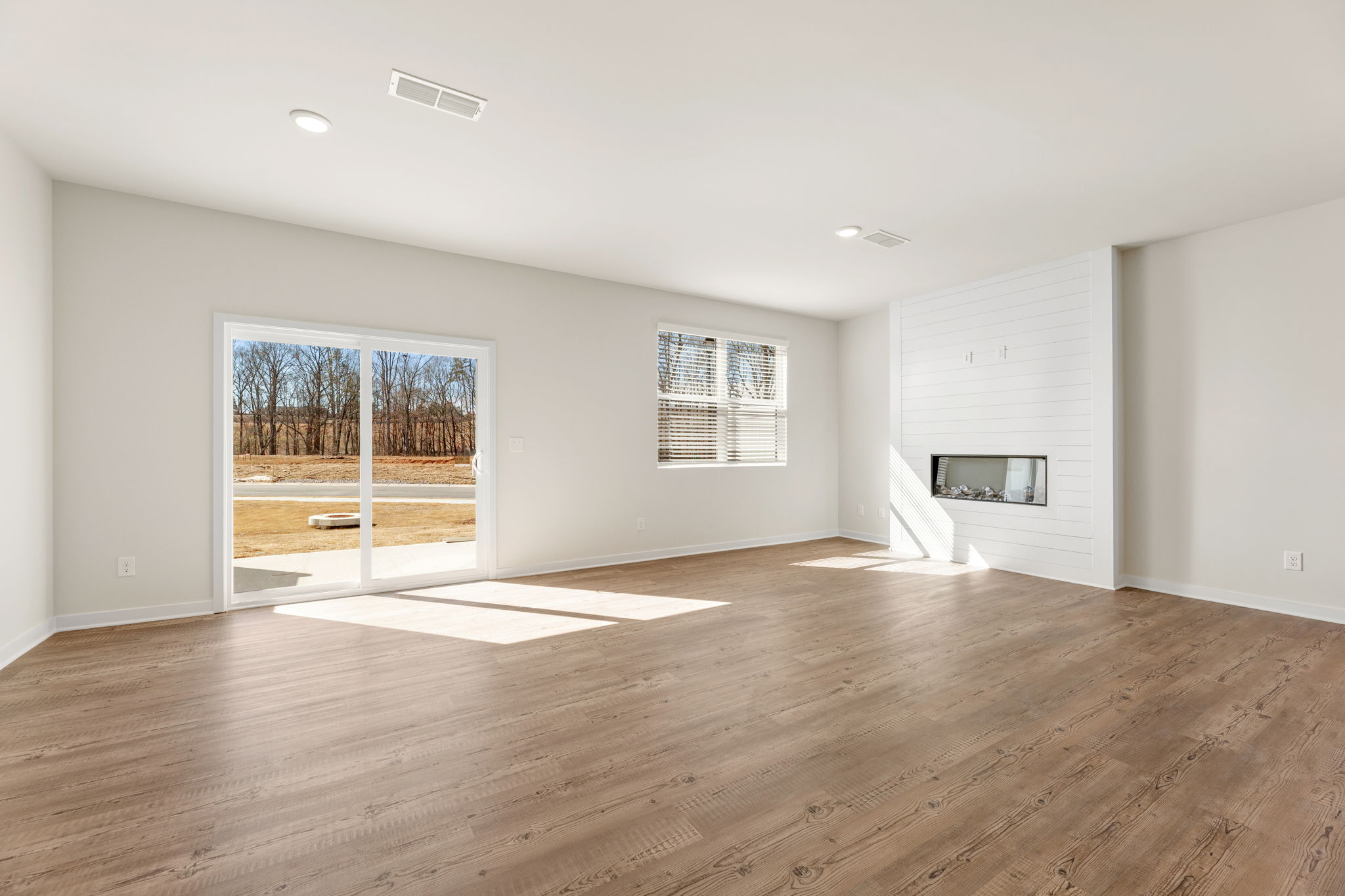 A room with a wood floor and a fireplace.