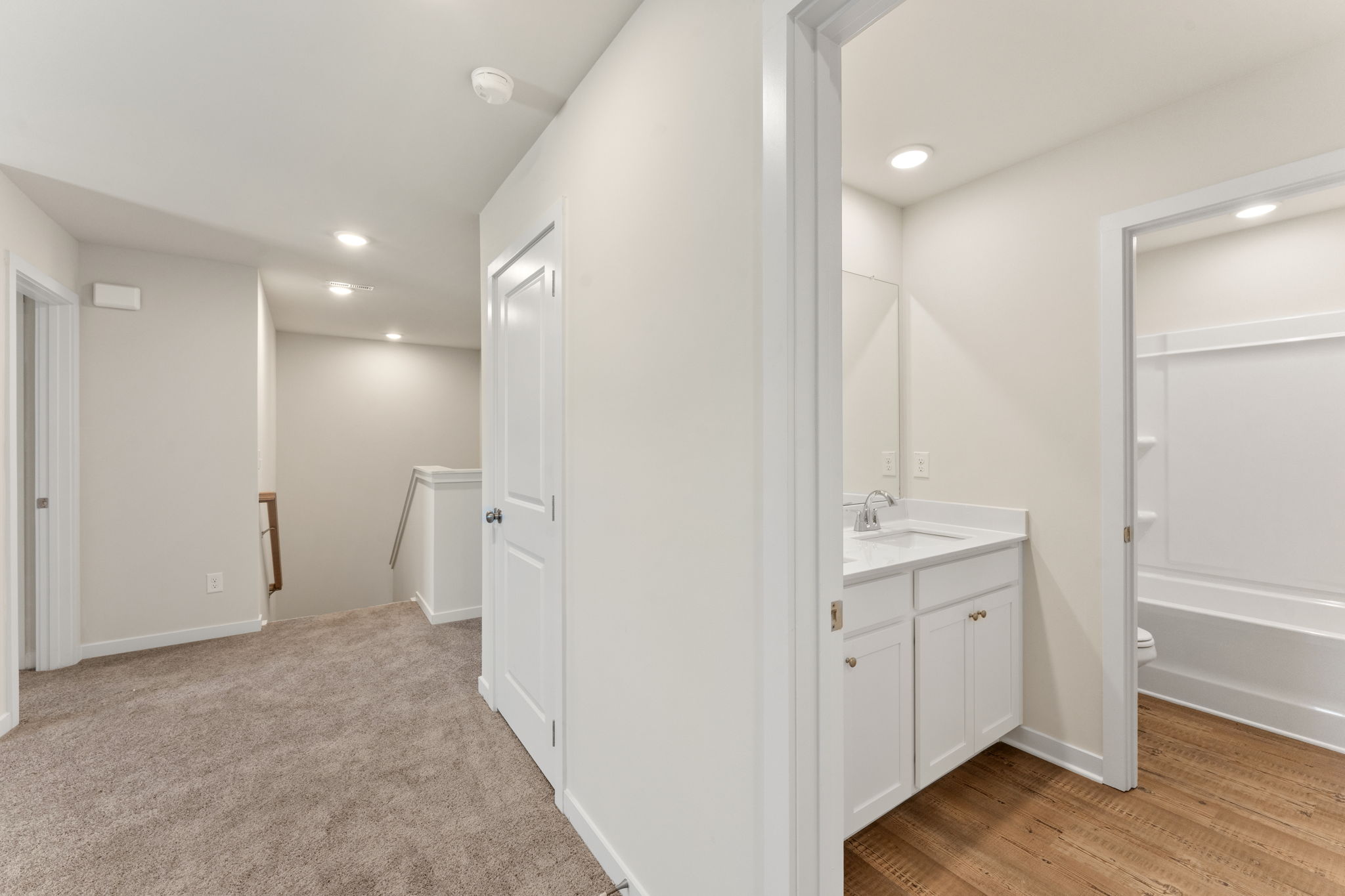 A bathroom with white cabinets.