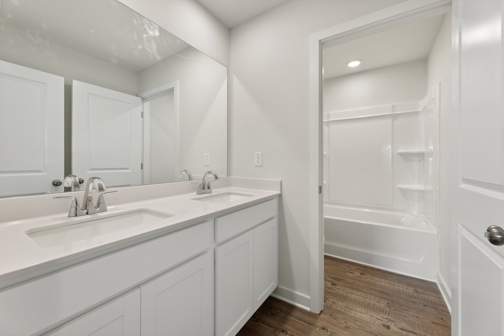 A bathroom with a tub sink and a shower.