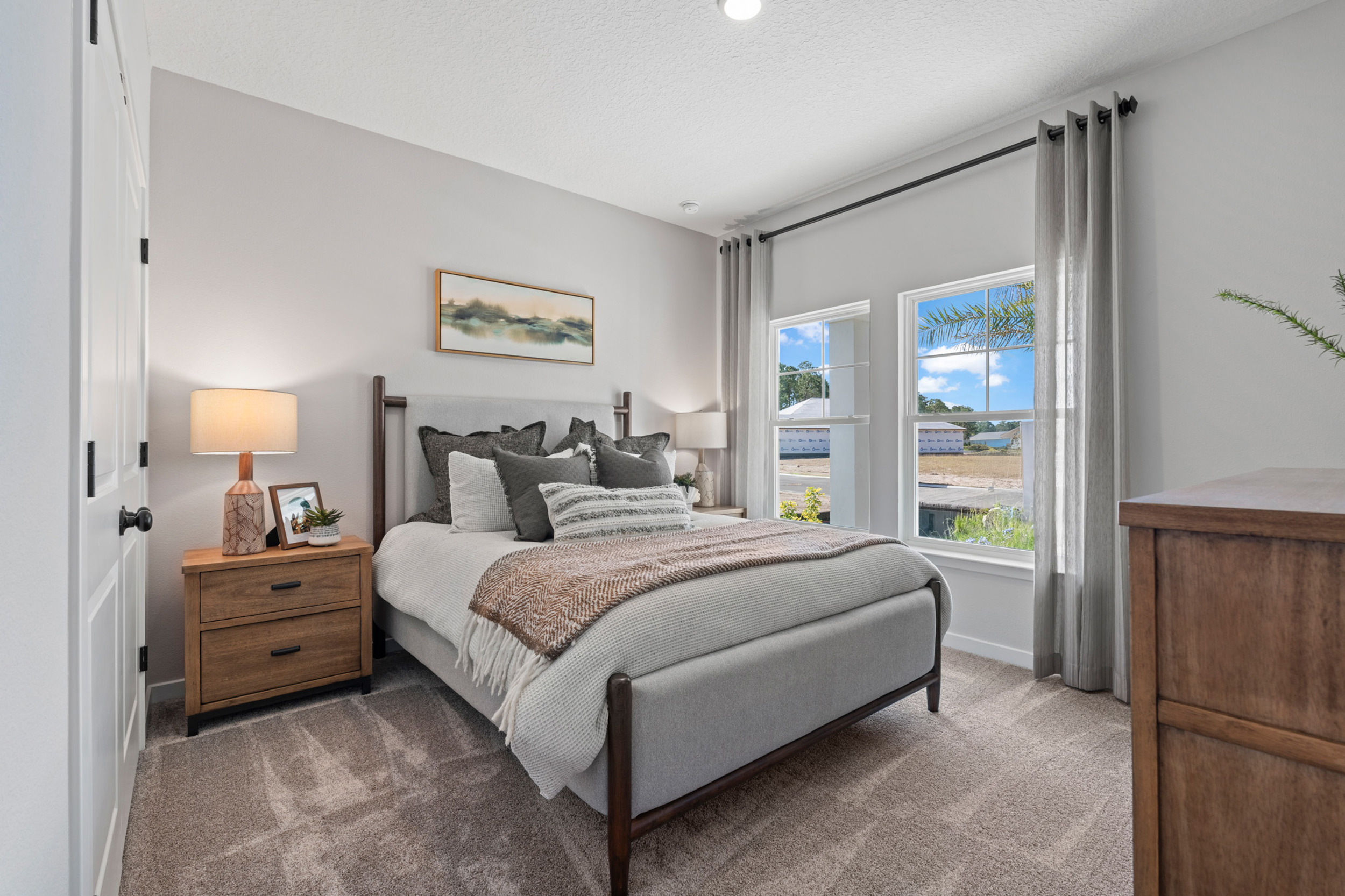 Kenai Model Home Guest Room with Large Bed and Two Nightstands at Reserve East in Flagler Beach