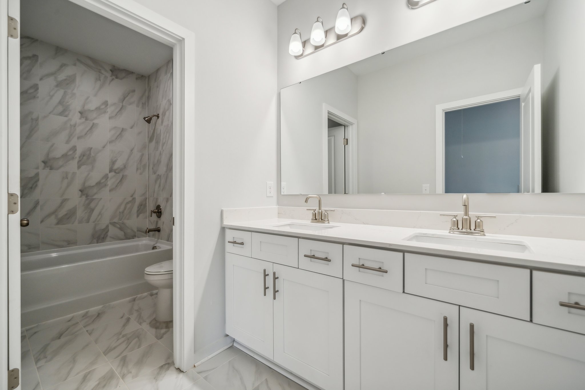 A bathroom with a tub sink and toilet.