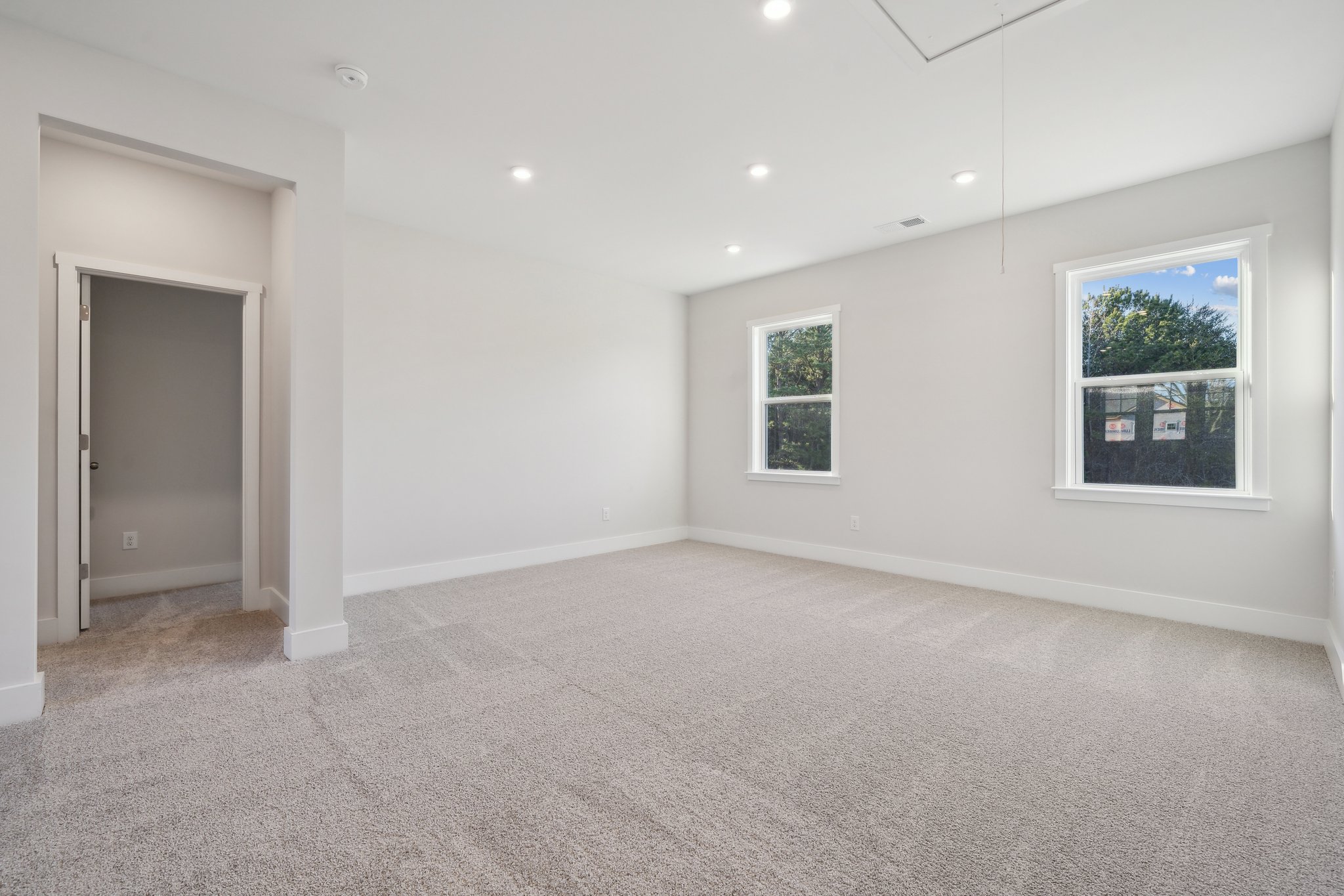 A room with a carpet and windows.