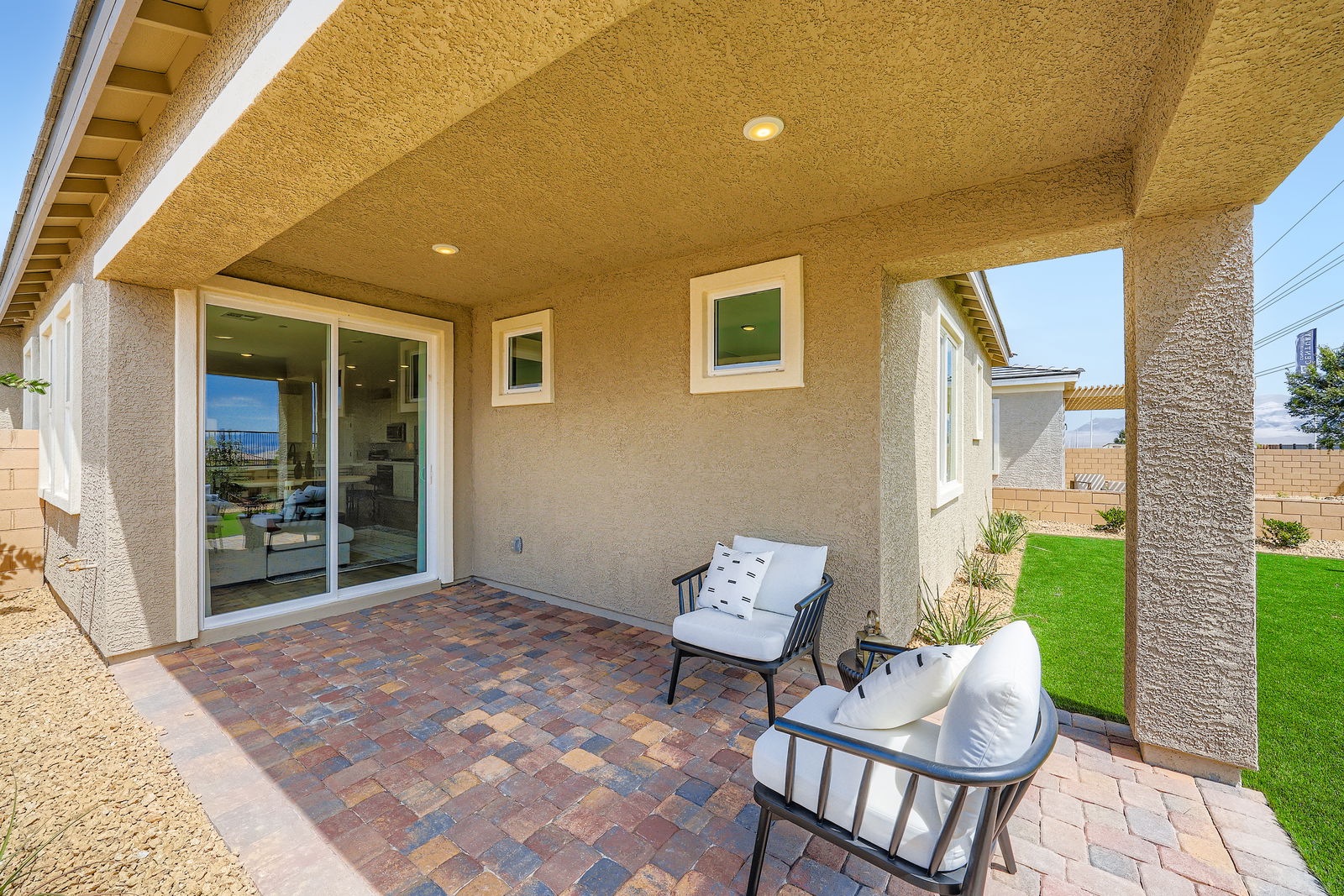 A patio with chairs and a glass door.