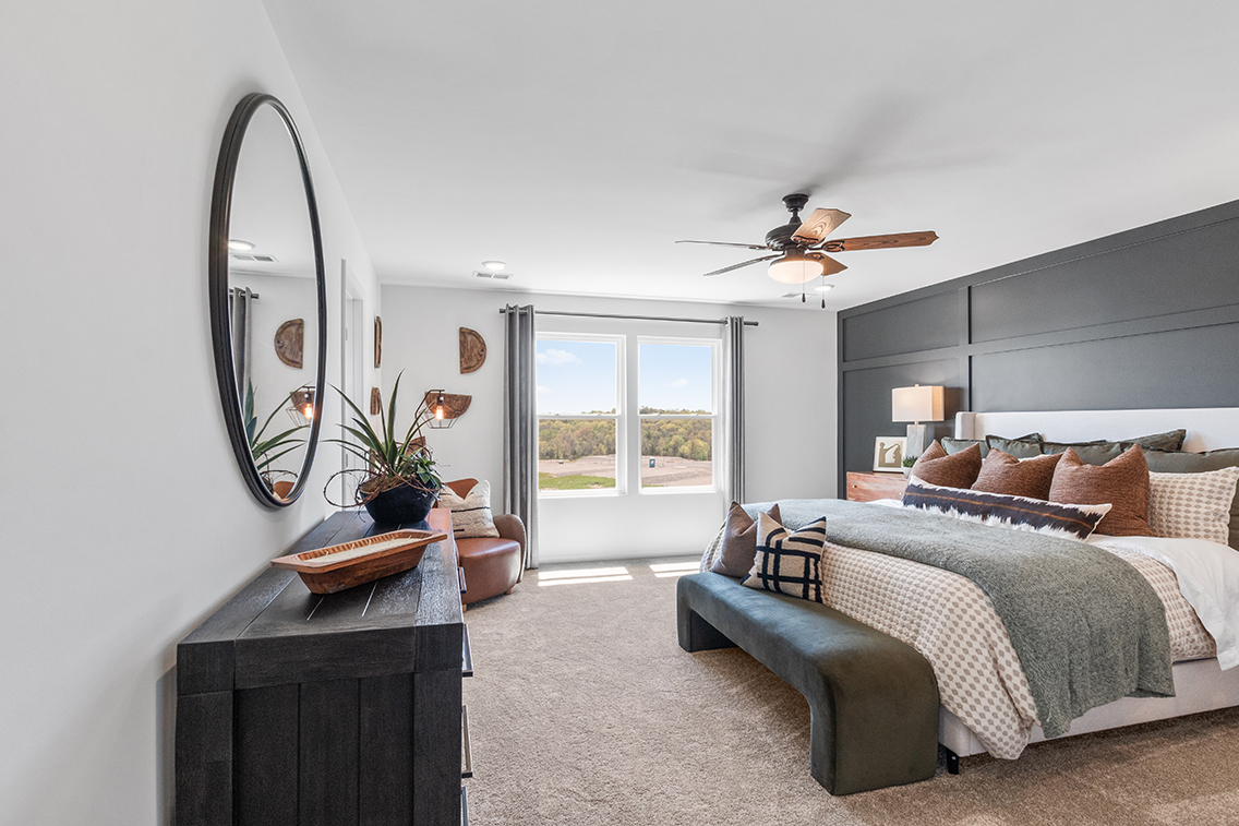 A bedroom with a large mirror.