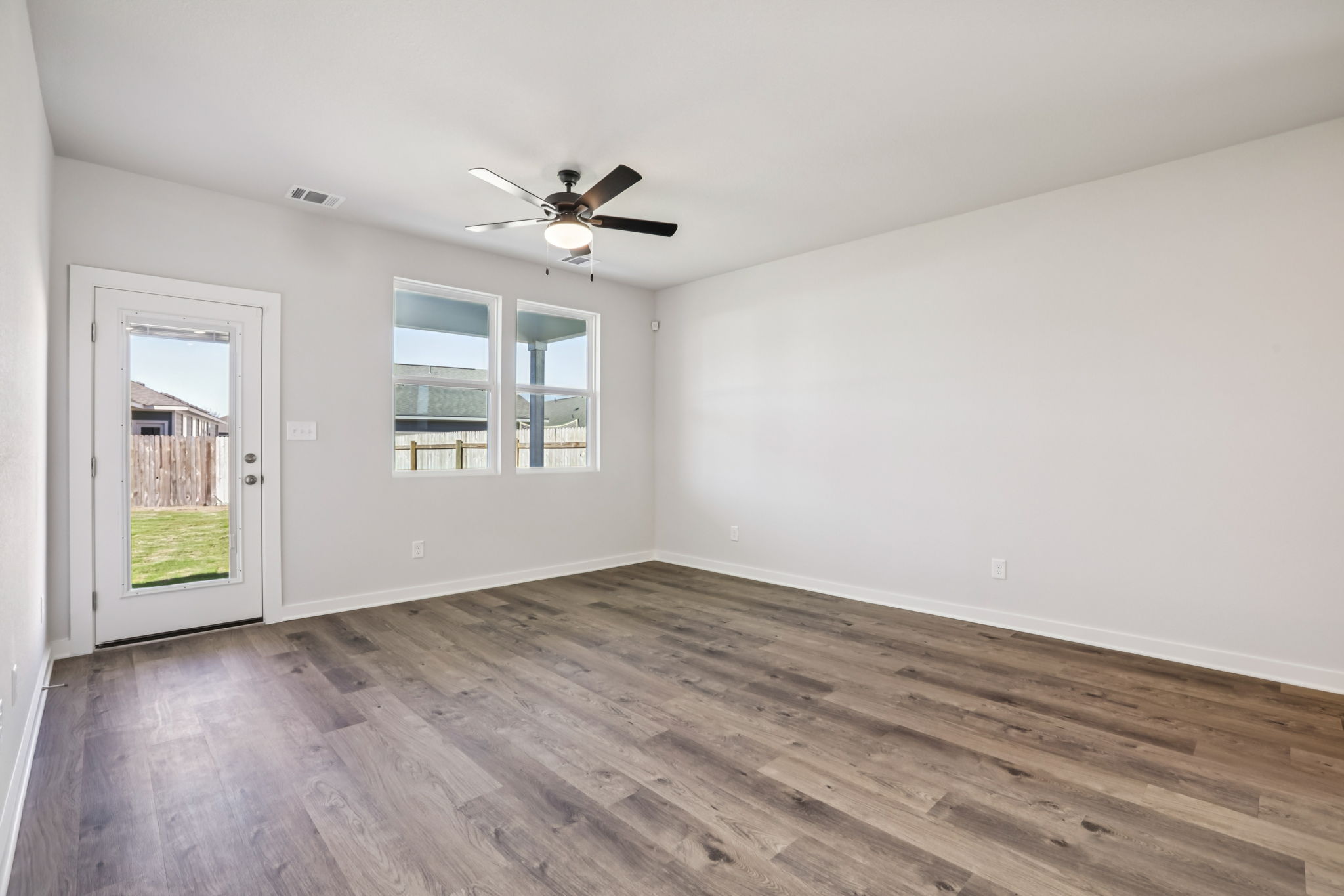 A room with a wood floor and a ceiling fan.