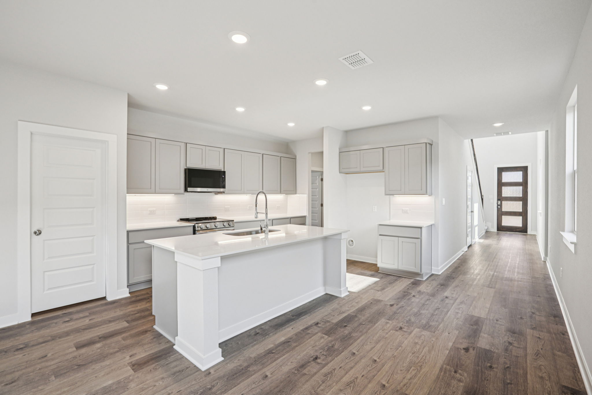 A kitchen with white cabinets.