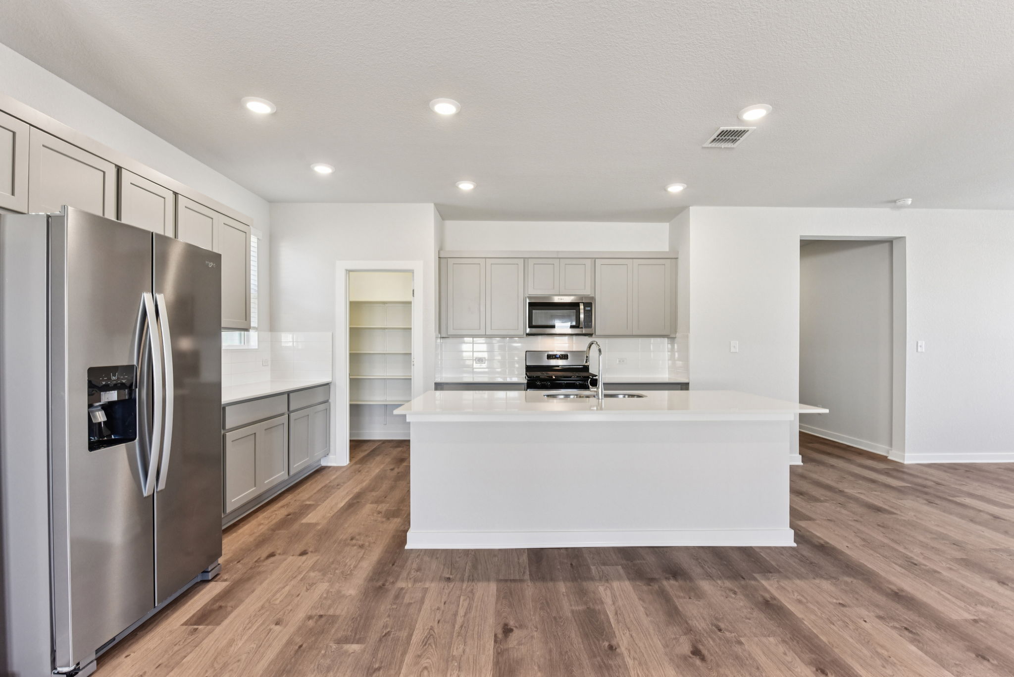A kitchen with white cabinets.