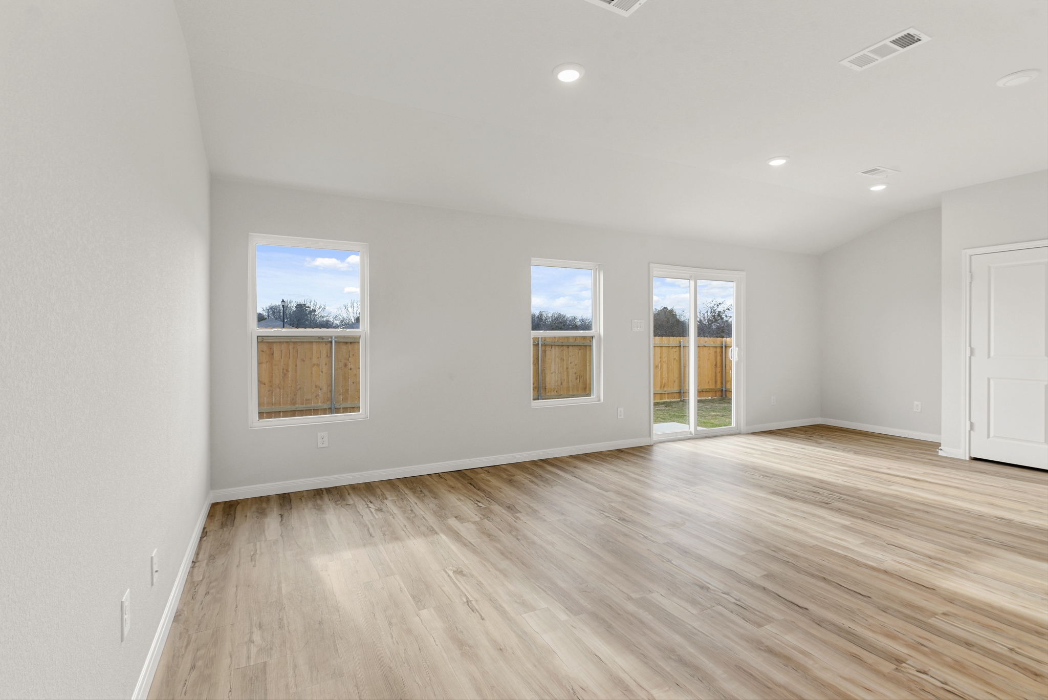 A room with a wood floor and windows.