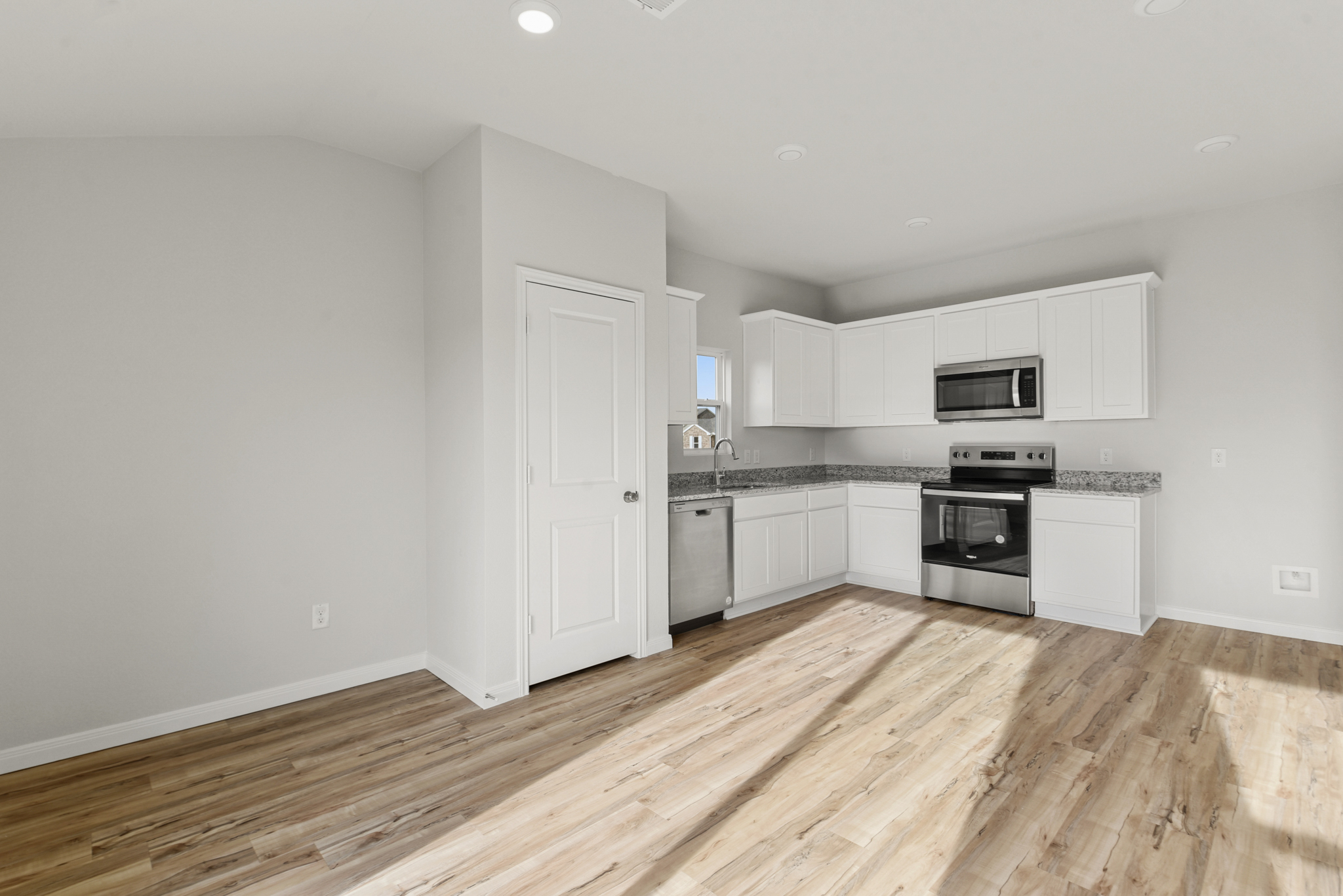 A kitchen with white cabinets.