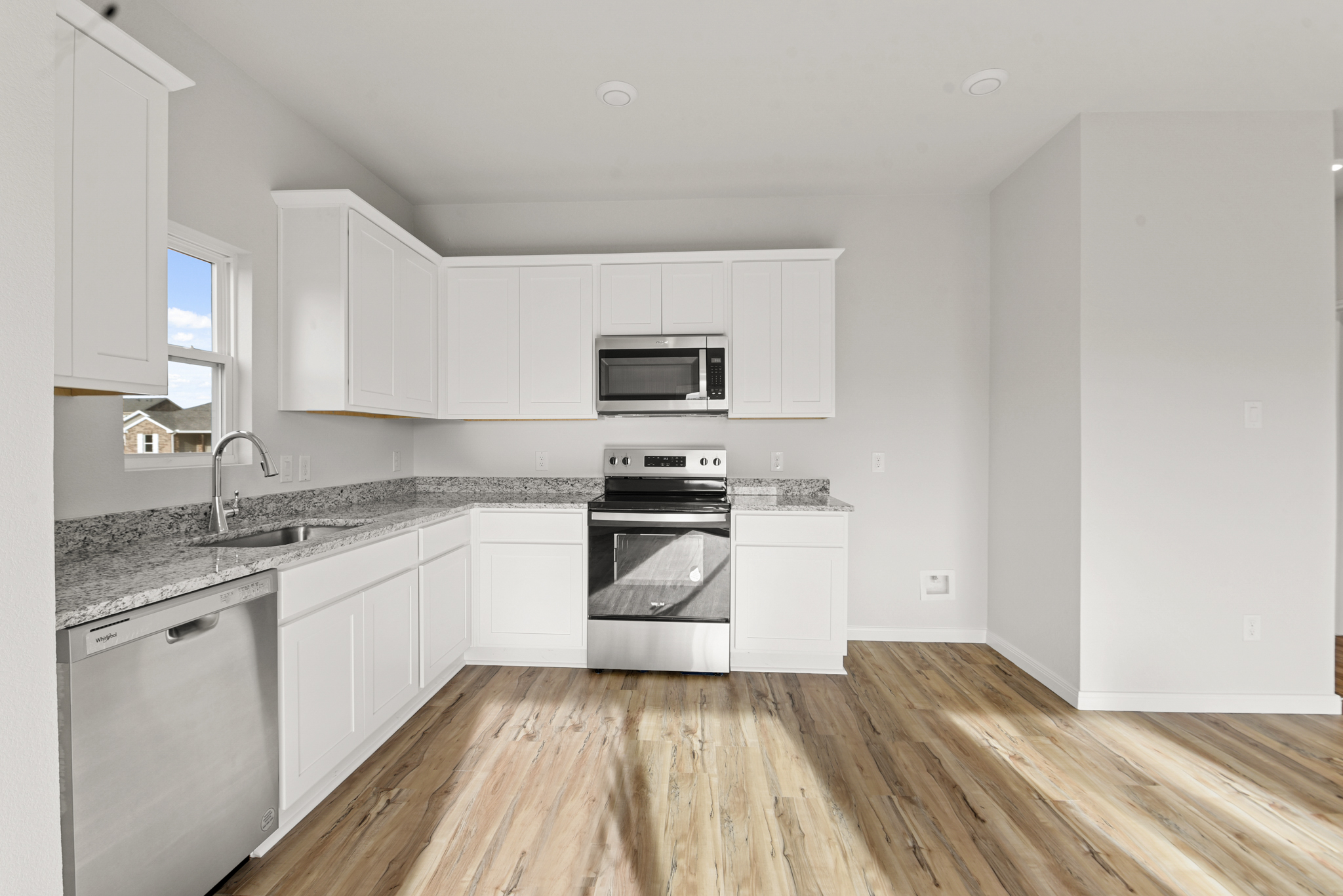 A kitchen with white cabinets.