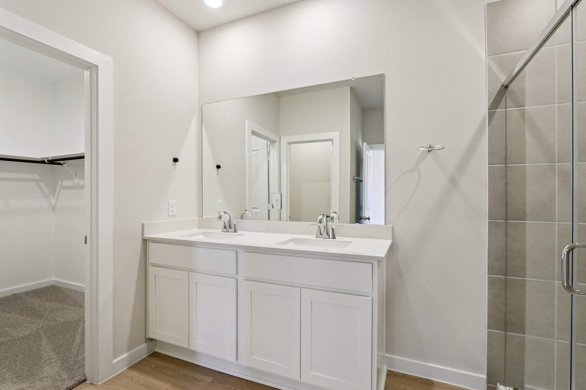 A bathroom with a sink and a shower unit.