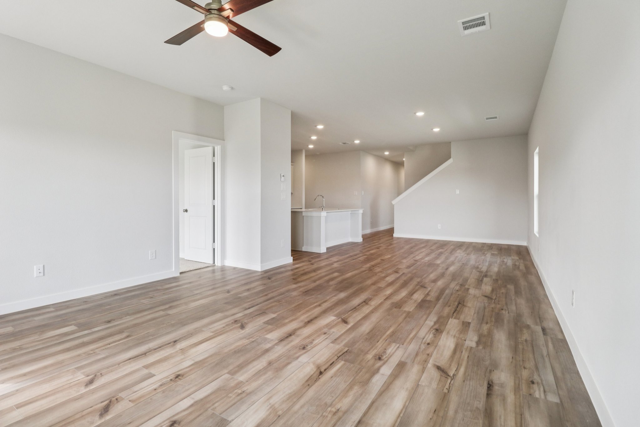 A room with a wood floor and a ceiling fan.