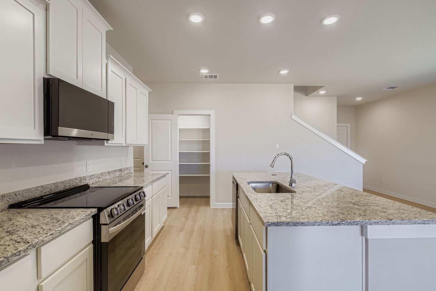 A kitchen with white cabinets.