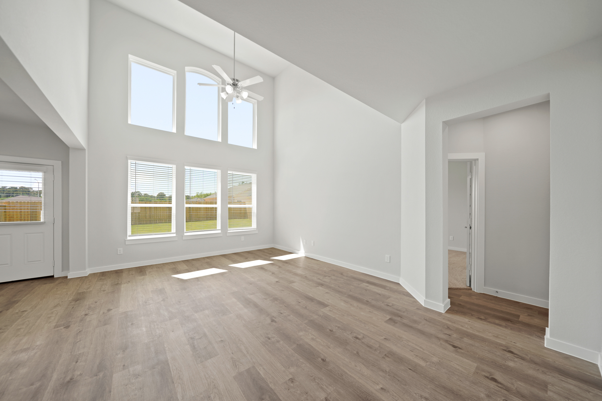 A room with a wood floor and a wood floor with a light on the ceiling.