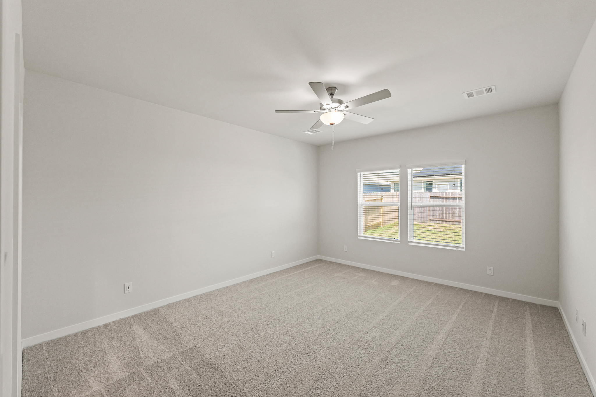 A room with a ceiling fan and a window.